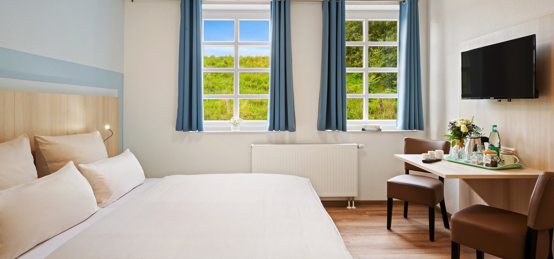 Doppelzimmer mit Tisch und Blick ins Grüne