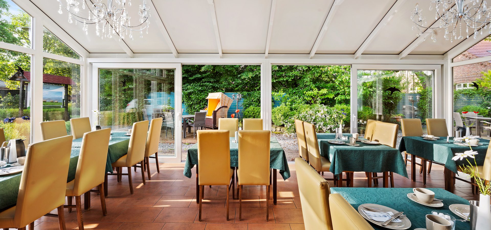 Gedeckte Tische im Wintergarten des Hotels