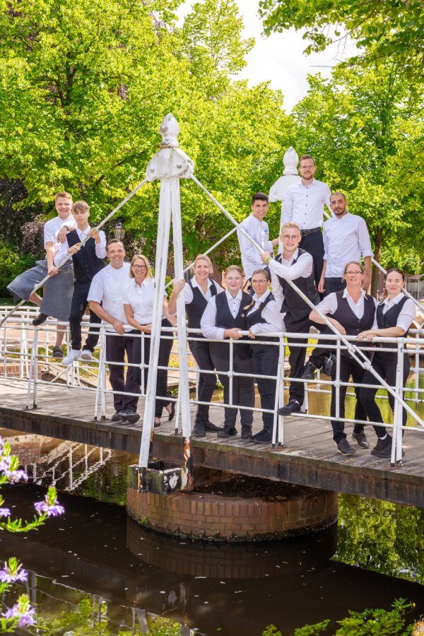 Das Team des Hotel und Restaurant des Alten Gasthaus Kuhr versammelt auf einer Brücke