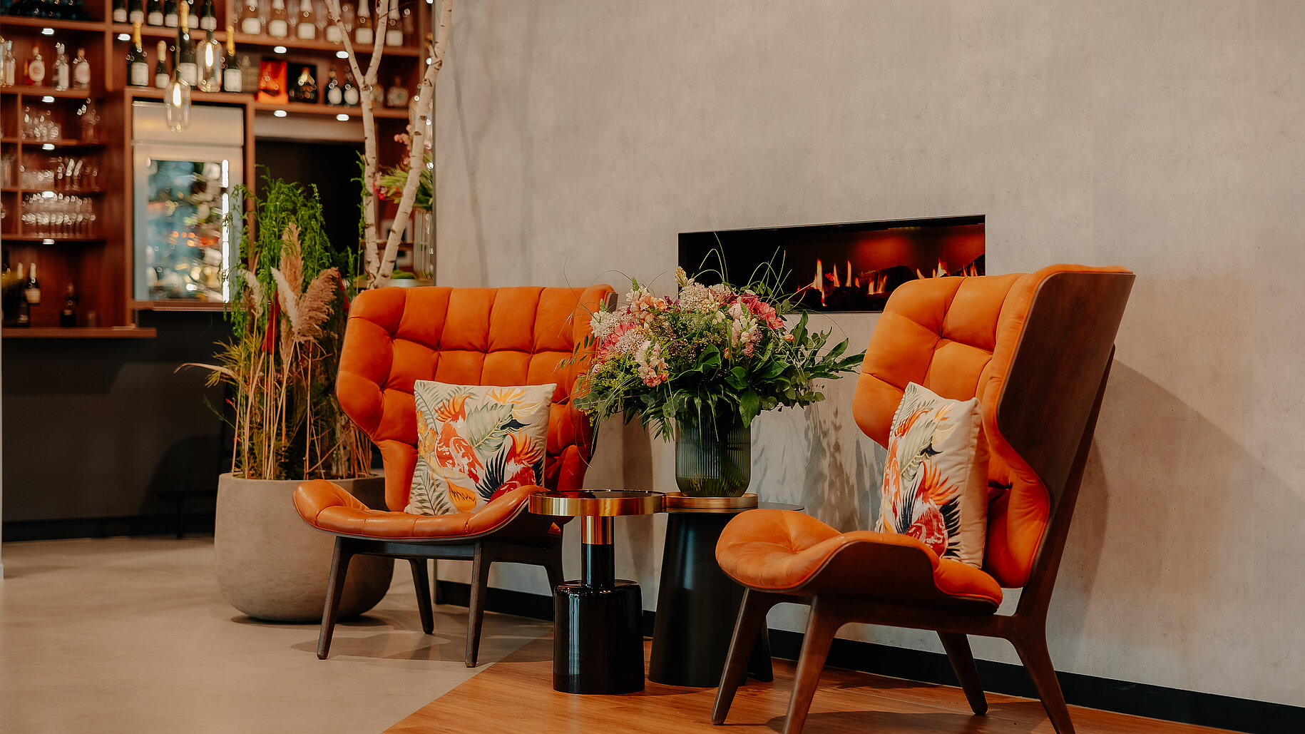 Gemütlicher Kaminbereich im VIA PLAZA Meppen mit Bar im Hintergrund